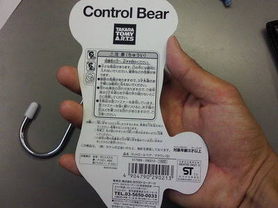 Control Bearのパッケージを持つ手とS字フックの画像。
