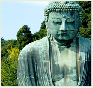 大仏の像が緑の木々を背景に立っている