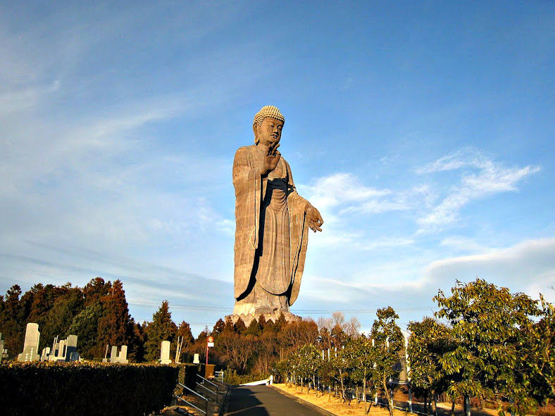 巨大な牛久大仏が青空を背景に立っている様子